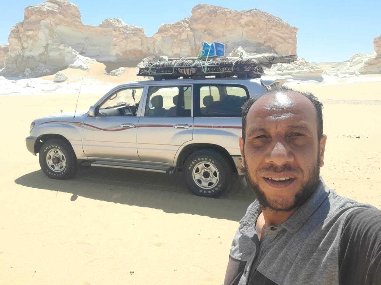 Yasser smiling in front of his 4x4 Land Cruiser in the White Desert